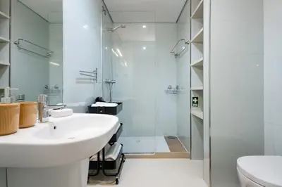 a white bathroom with a sink and a shower at Boavista Loft in Porto