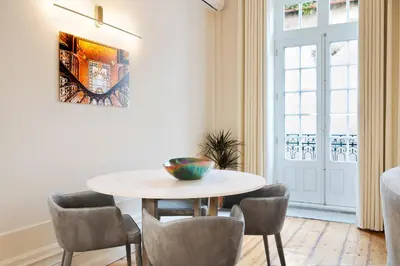 a table and chairs in a room with a window at 42 2 F Historical apartment at Cardosas Block in Porto