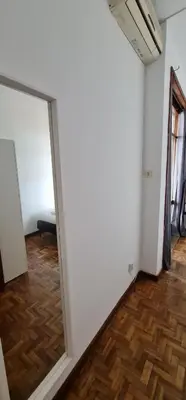 a mirror in a white room with a wooden floor at Leote in Porto