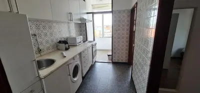 a kitchen with a sink and a washing machine at Leote in Porto