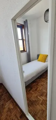 a small room with a bed with a window at Leote in Porto
