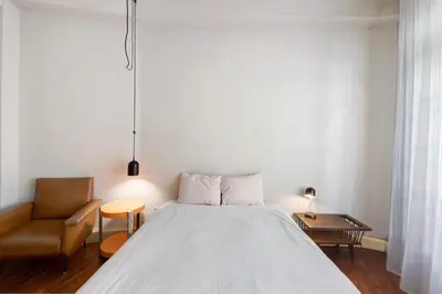 a bedroom with a bed and a chair at A Casa Formosa in Porto