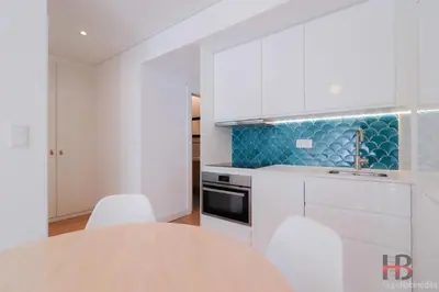 a kitchen with white cabinets and a table and chairs at Good Vibes Only by LovelyStay in Porto