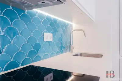 a bathroom with a blue tiled wall with a sink at Good Vibes Only by LovelyStay in Porto