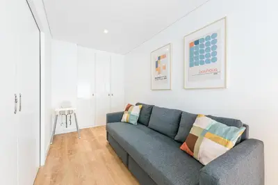 a living room with a blue couch and white walls at Good Vibes Only by LovelyStay in Porto