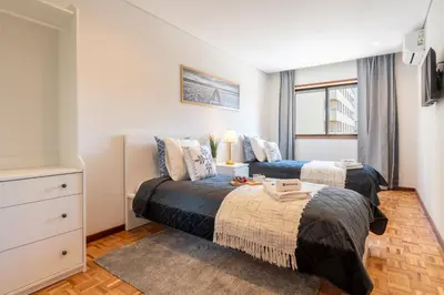 a bedroom with two beds and a window at Host Wise - Bright and Elegant Urban Flat with Balcony in Porto