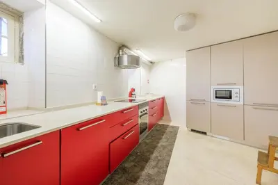 a bedroom with a white bed and a refrigerator at GuestReady - Historic Courtyard Townhouse in Porto