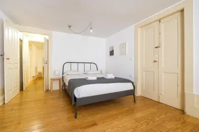 three towels are stacked on a white bed at GuestReady - Historic Courtyard Townhouse in Porto