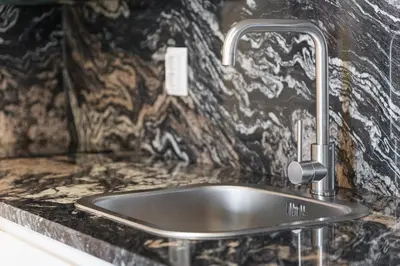 a sink in a bathroom with a stone wall at GuestReady - Contemporary cabin in Santos Pousada in Porto
