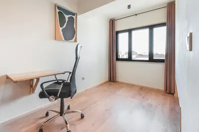 a desk and a chair in a room with a window at GuestReady - Contemporary cabin in Santos Pousada in Porto