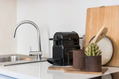 a kitchen counter with a sink and a coffee maker at GuestReady - Naoki Studio in Porto
