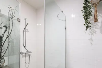 a shower with a glass door in a bathroom at GuestReady - Naoki Studio in Porto