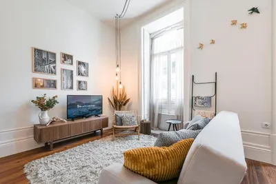 a living room with a couch and a tv at GuestReady - Naoki Studio in Porto