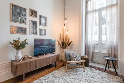 a living room with a flat screen tv on a wooden entertainment center at GuestReady - Naoki Studio in Porto