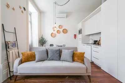 a living room with a couch and a kitchen at GuestReady - Naoki Studio in Porto