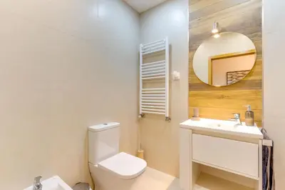 a bathroom with a toilet and a sink and a mirror at Cozy Nest in Porto