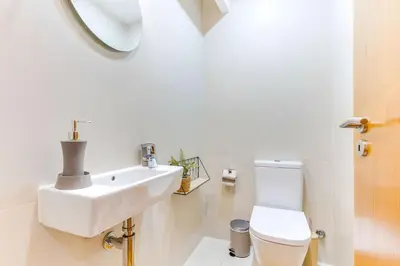 a white bathroom with a sink and a toilet at Cozy Nest in Porto