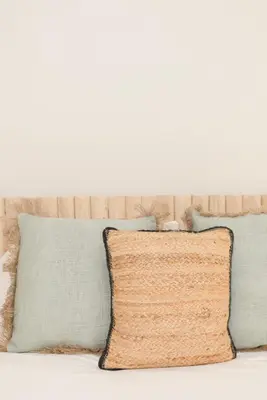 a pile of pillows on a bed with a white wall at Liiiving in Porto - Bolhao Garden Apartment in Porto