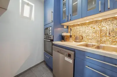 a kitchen with blue cabinets and a sink at Alegria Duplex by Hosty in Porto