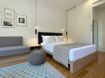 a hotel room with two beds and a couch at Essência Portuense Studios in Porto