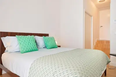 a bedroom with a bed with green and white pillows at Take me to Aliados in Porto