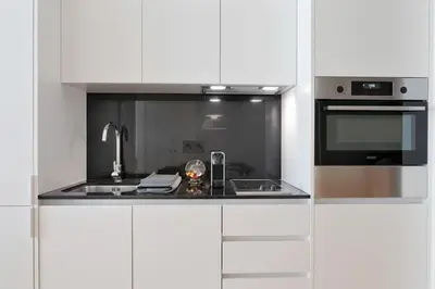 a white kitchen with a sink and a stove at Take me to Aliados in Porto