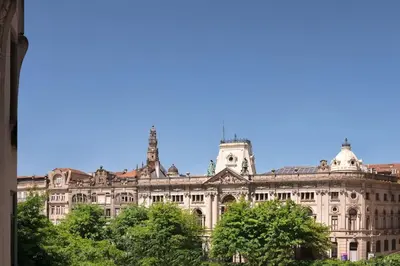 a large building with trees in front of it at Take me to Aliados in Porto