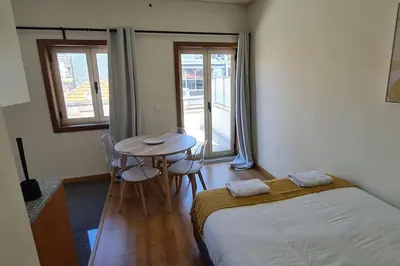 a bedroom with a bed and a table with chairs at Tomás FLAT 4F in Porto