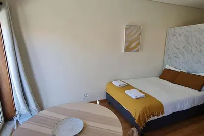 a small bedroom with a bed and a table at Tomás FLAT 4F in Porto