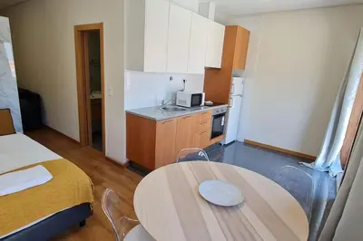 a small kitchen with a table and a bed at Tomás FLAT 4F in Porto