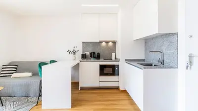 a small kitchen with white cabinets and a bed at Infante Studio w Parking by LovelyStay in Vila Nova de Gaia