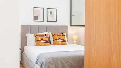 a bedroom with a bed with orange pillows at Infante Studio w Parking by LovelyStay in Vila Nova de Gaia