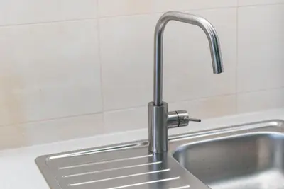 a kitchen sink with a chrome kitchen faucet at GuestReady - Lightform Apartment in Porto