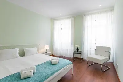 a bedroom with a white bed and a chair at GuestReady - Lightform Apartment in Porto