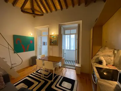 a living room with a table and chairs in a room at Aliados Historic Downtown Apartments by LuxiStay in Porto