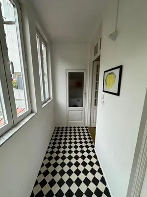 a hallway with a black and white checkered floor at Aliados Historic Downtown Apartments by LuxiStay in Porto