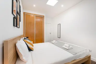 a bedroom with a bed with a wooden headboard at GuestReady - Serene Hideout in Downtown in Porto