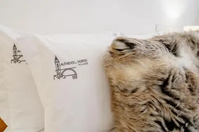 a cat laying on a bed next to a white pillow at Authentic Porto Village in Porto