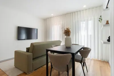 a living room with a table and a green couch at GuestReady - Tranquil haven in the city centre in Porto