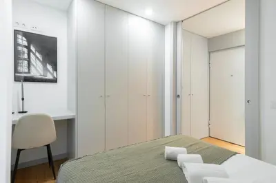 a bedroom with a bed and a desk and a chair at GuestReady - Tranquil haven in the city centre in Porto