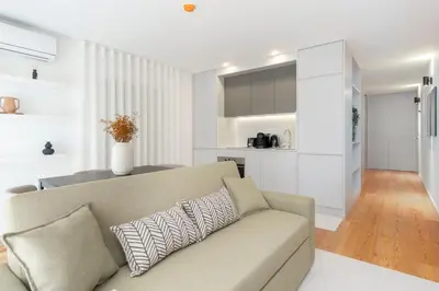 a living room with a couch and a kitchen at GuestReady - Tranquil haven in the city centre in Porto