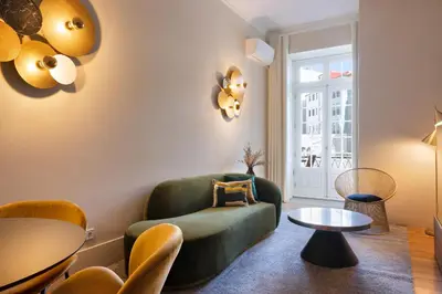 a living room with a green chair and a table at 42 1T Cardosas Block Historic Ap in Porto