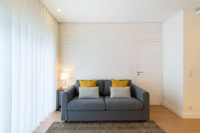 a blue couch in a living room with yellow pillows at GuestReady - Modern 2-Bedroom Apt in Cedofeita in Porto