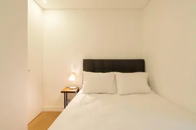 a bedroom with a white bed with a black headboard at GuestReady - Modern 2-Bedroom Apt in Cedofeita in Porto