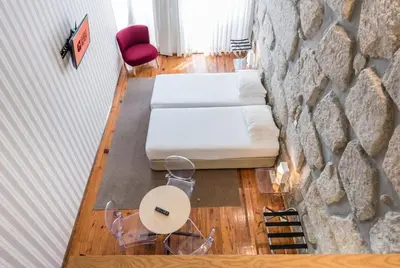 a bedroom with a stone wall and a table and chairs at GuestReady - Porto de Rio Residences in Porto