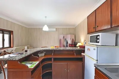 a kitchen with a counter with a microwave and a refrigerator at Bessa - Casinha Típica do Porto com dois quartos in Porto