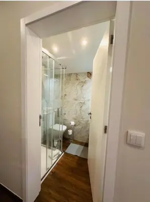 a bathroom with a walk in shower and a glass door at Bridge Apartment in Porto