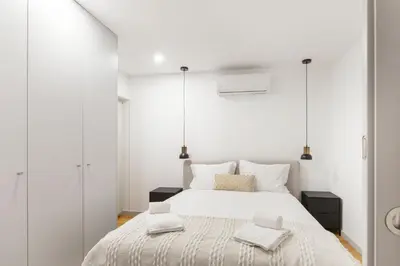 a white bedroom with a large bed with white walls at GuestReady - Trendy getaway in the heart of Porto in Porto