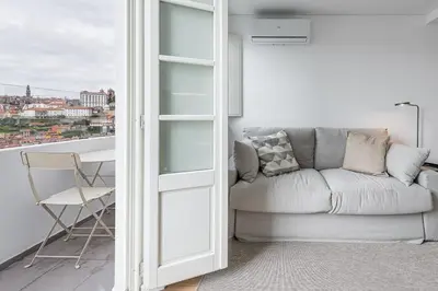 a living room with a couch and a balcony at GuestReady - Riverview Douro Balcony in Vila Nova de Gaia