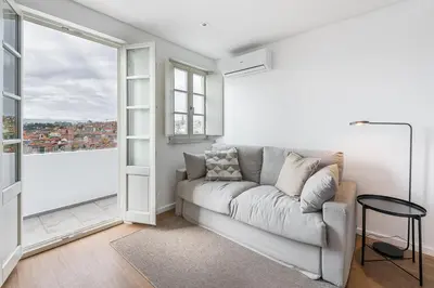 a living room with a couch and a large window at GuestReady - Riverview Douro Balcony in Vila Nova de Gaia